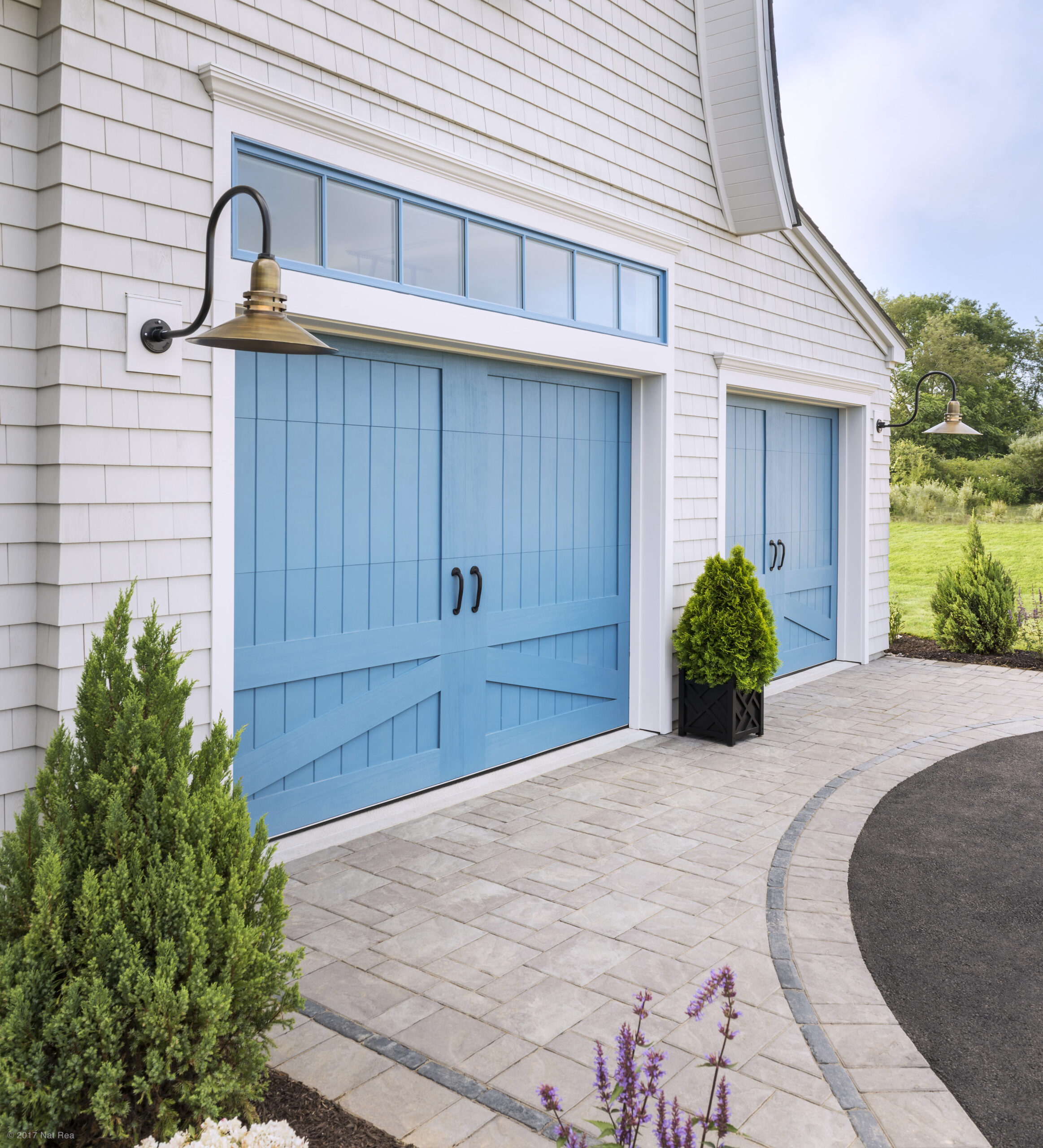 bright blue garage doors attached to a white house